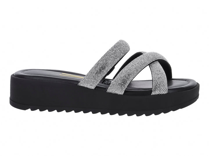 Sandalia de plataforma negra con tiras cruzadas plateadas brillantes y suela dentada.