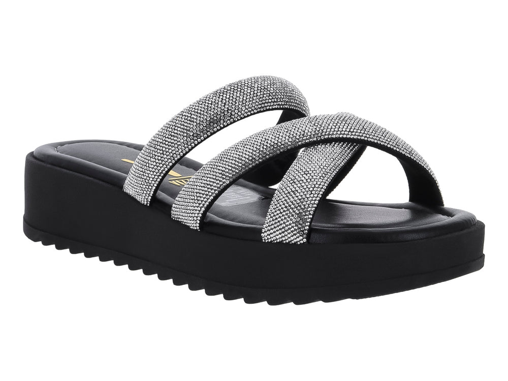 Sandalia de plataforma negra con tiras cruzadas plateadas brillantes y suela dentada.