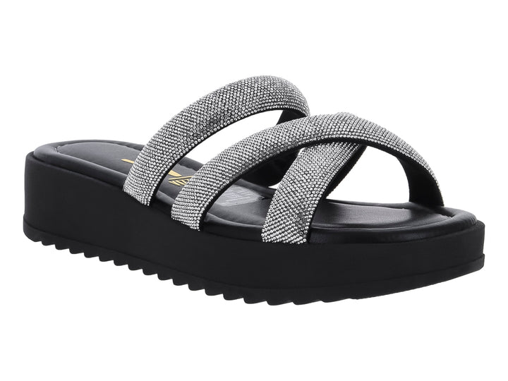 Sandalia de plataforma negra con tiras cruzadas plateadas brillantes y suela dentada.