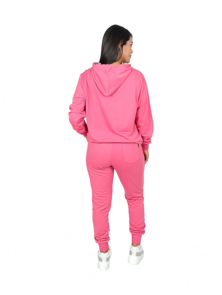 Mujer vistiendo un conjunto deportivo de sudadera con capucha y pants en color rosa.