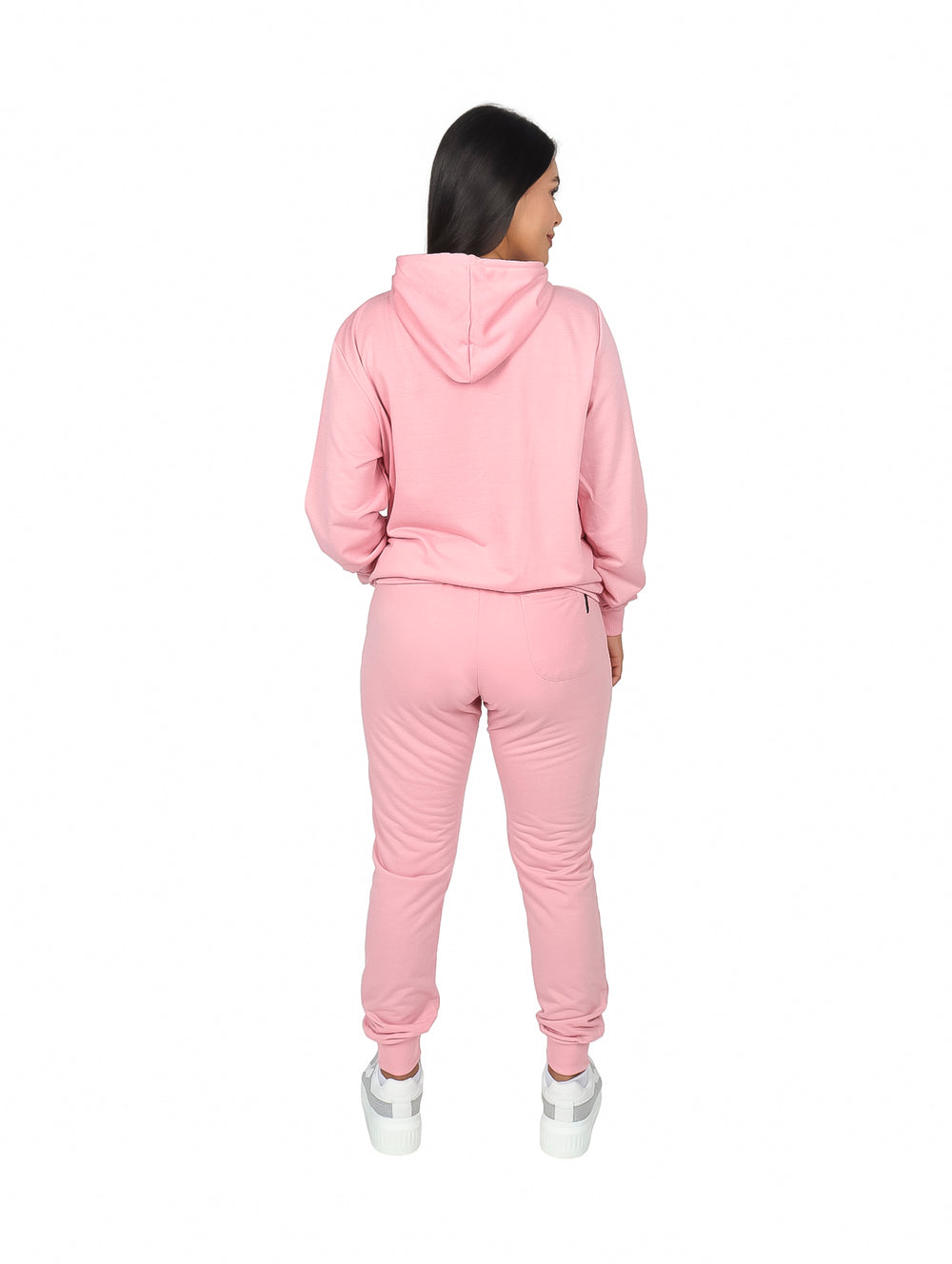 Mujer vistiendo un conjunto deportivo color salmón compuesto por sudadera con capucha y pants.
