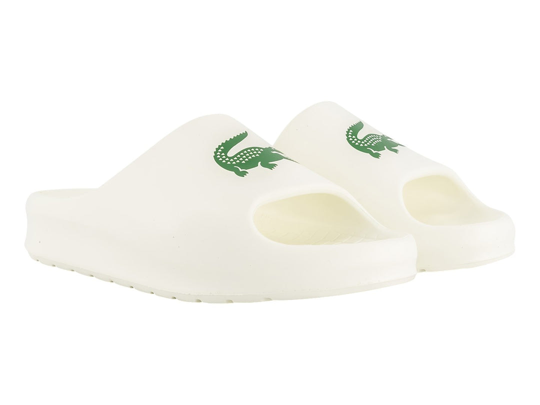 Sandalia tipo slide de color blanco con logo verde de Lacoste en la correa.