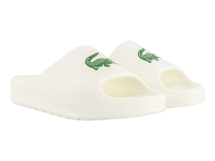 Sandalia tipo slide de color blanco con logo verde de Lacoste en la correa.