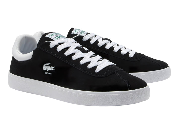 Tenis Lacoste negros con suela y cordones blancos.