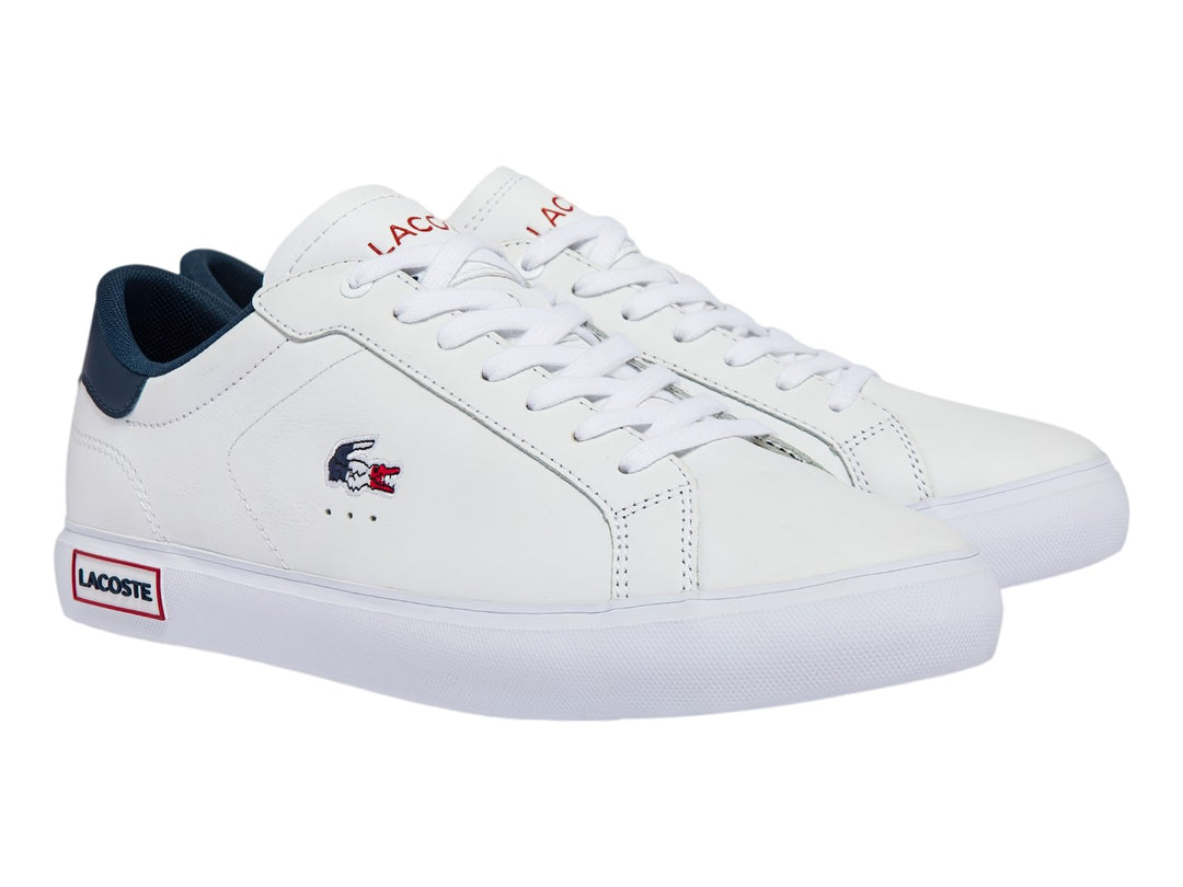 Tenis Lacoste Powercourt color blanco con detalles en azul marino y rojo, diseño casual de cuero sintético.