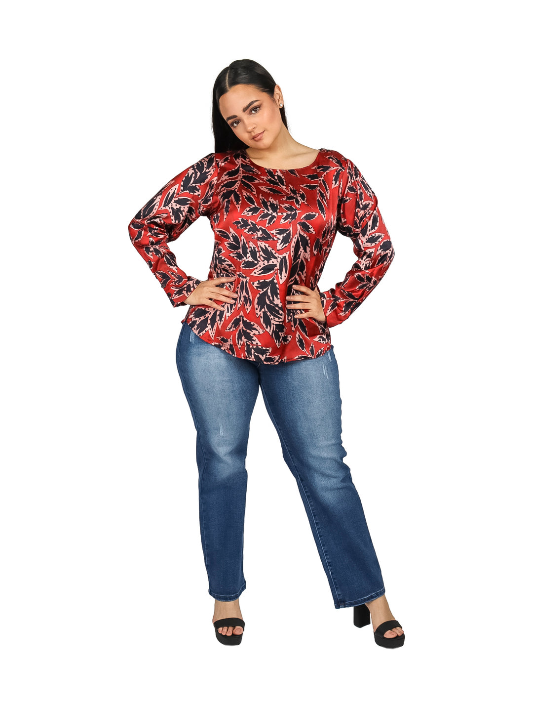 Mujer vistiendo una blusa roja con estampado de hojas negras y manga larga.