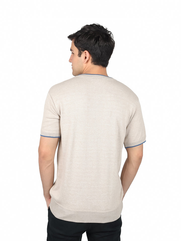 Hombre vistiendo playera beige de manga corta y cuello redondo con ribete azul en los bordes.