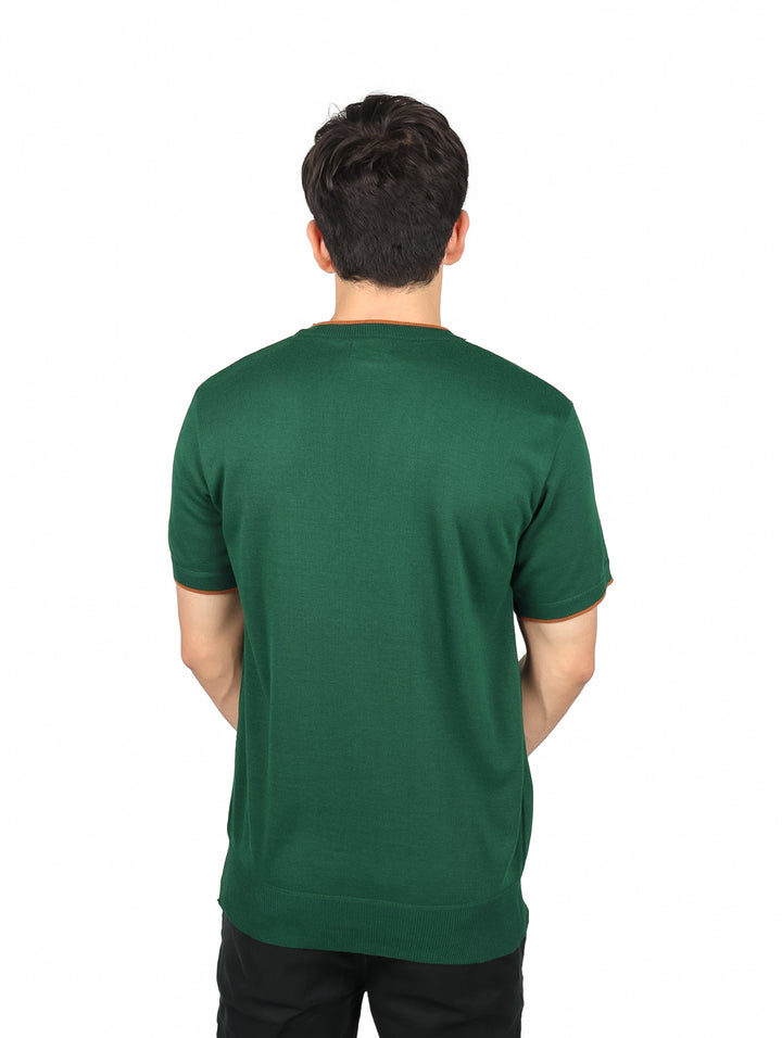 Hombre vistiendo playera verde oliva de manga corta y cuello redondo con detalles en color marrón en los bordes.