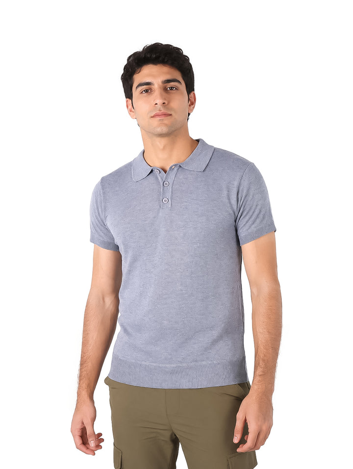Hombre vistiendo una playera tipo polo de color gris claro con botones y manga corta.