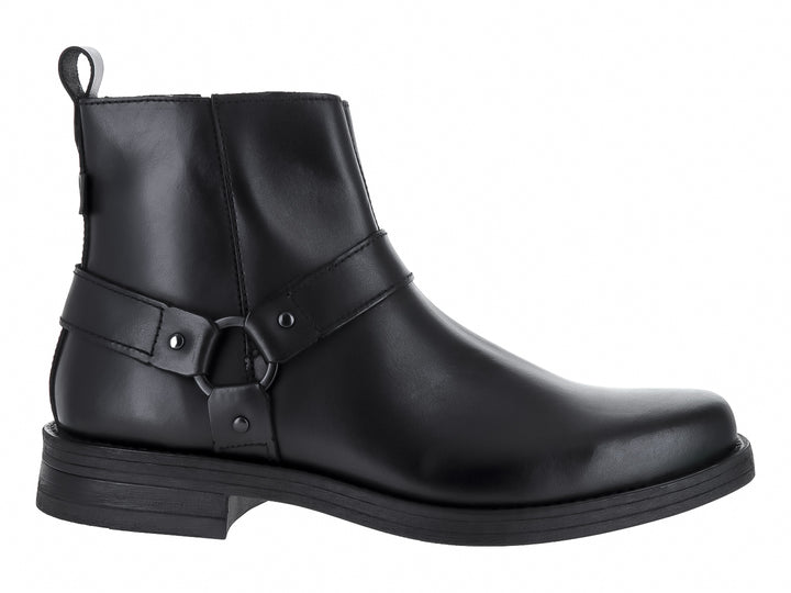 Bota negra de material sintético con correa y aro decorativo en el tobillo.