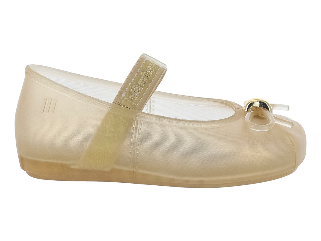 Zapato Mini Melissa modelo Sophie en color beige, con correa superior y detalle decorativo al frente.