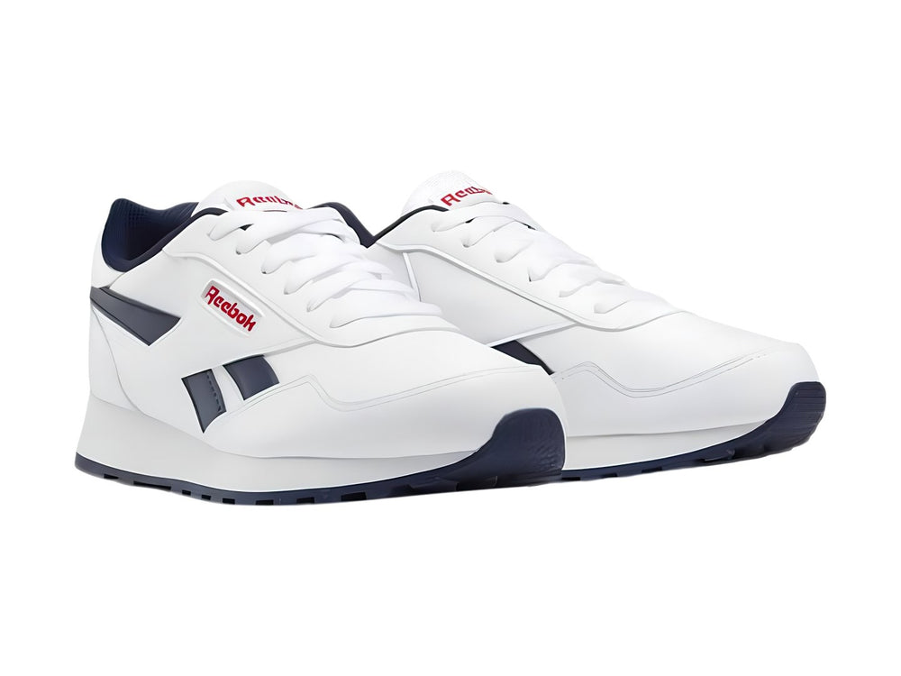 Tenis deportivos Reebok blancos con detalles en azul marino y rojo para niños.