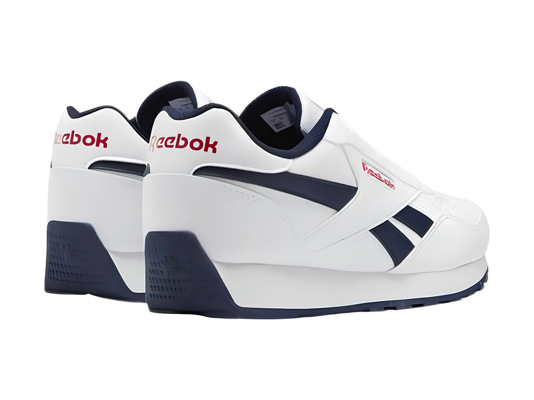 Tenis deportivos Reebok blancos con detalles en azul marino y rojo para niños.