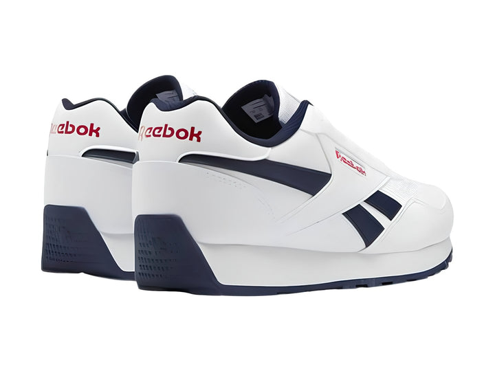Tenis deportivos Reebok blancos con detalles en azul marino y rojo para niños.