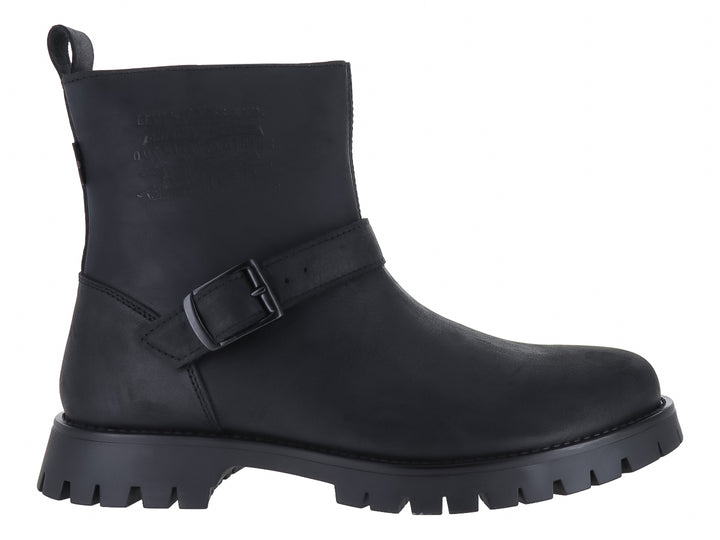 Botas negras de caña corta con suela track y correa con hebilla lateral.