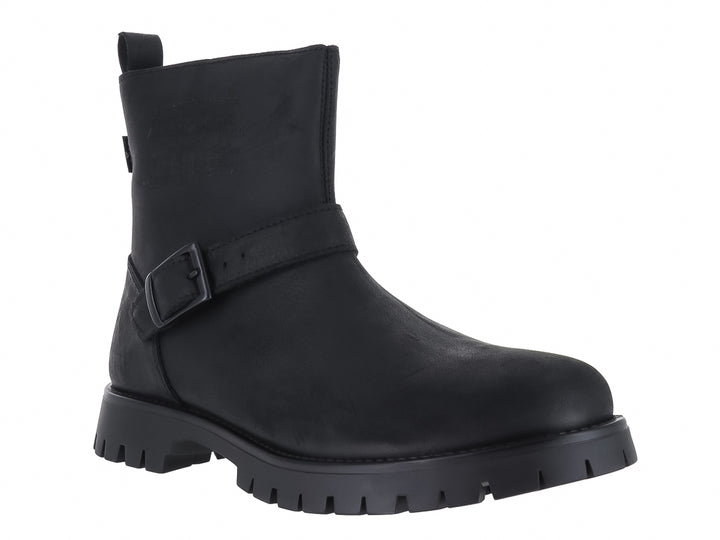 Botas negras de caña corta con suela track y correa con hebilla lateral.