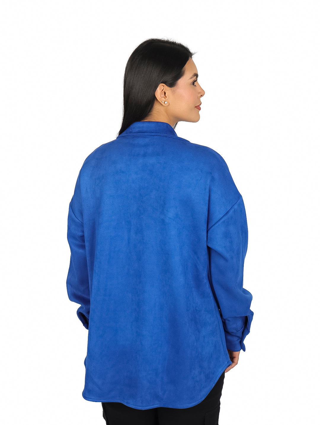 Mujer vistiendo una camisola de gamuza color azul royal con botones frontales y bolsillos en el pecho.