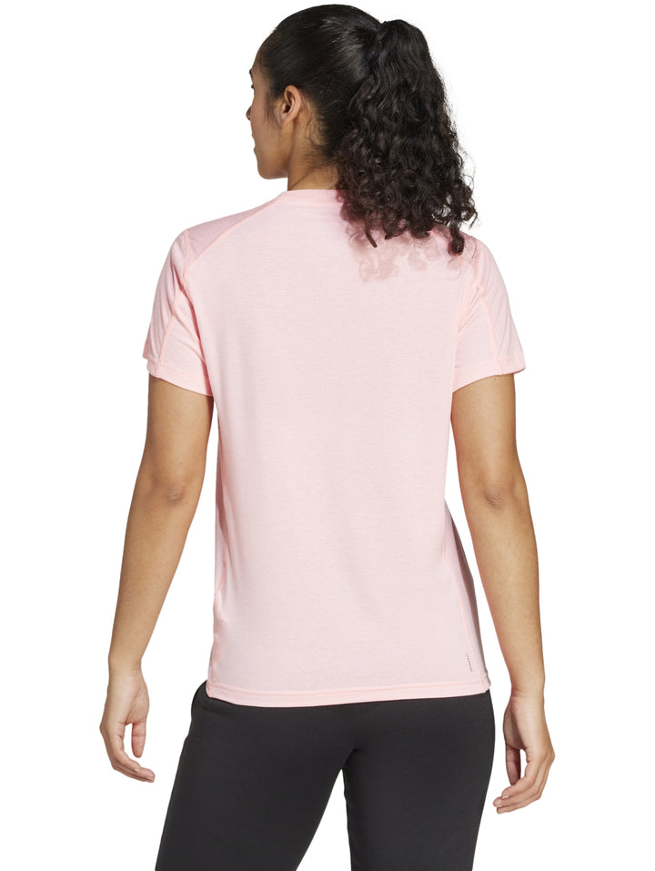 Mujer vistiendo playera de entrenamiento Adidas en color rosa claro con cuello redondo y manga corta.