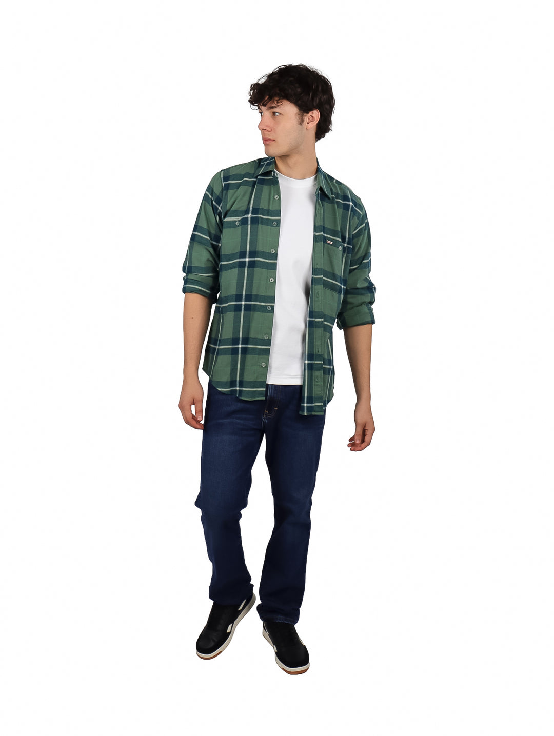 Hombre vistiendo una camisa de franela verde a cuadros con corte slim, combinada con camiseta blanca y jeans azules.