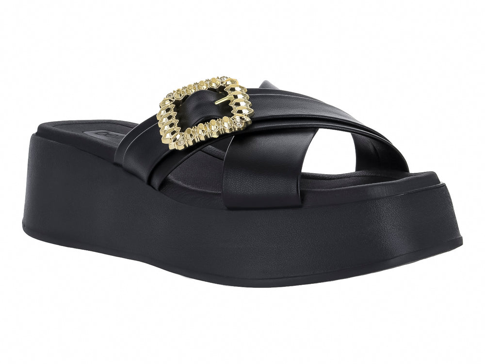 Sandalia negra de plataforma con hebilla decorativa dorada brillante en la parte superior.