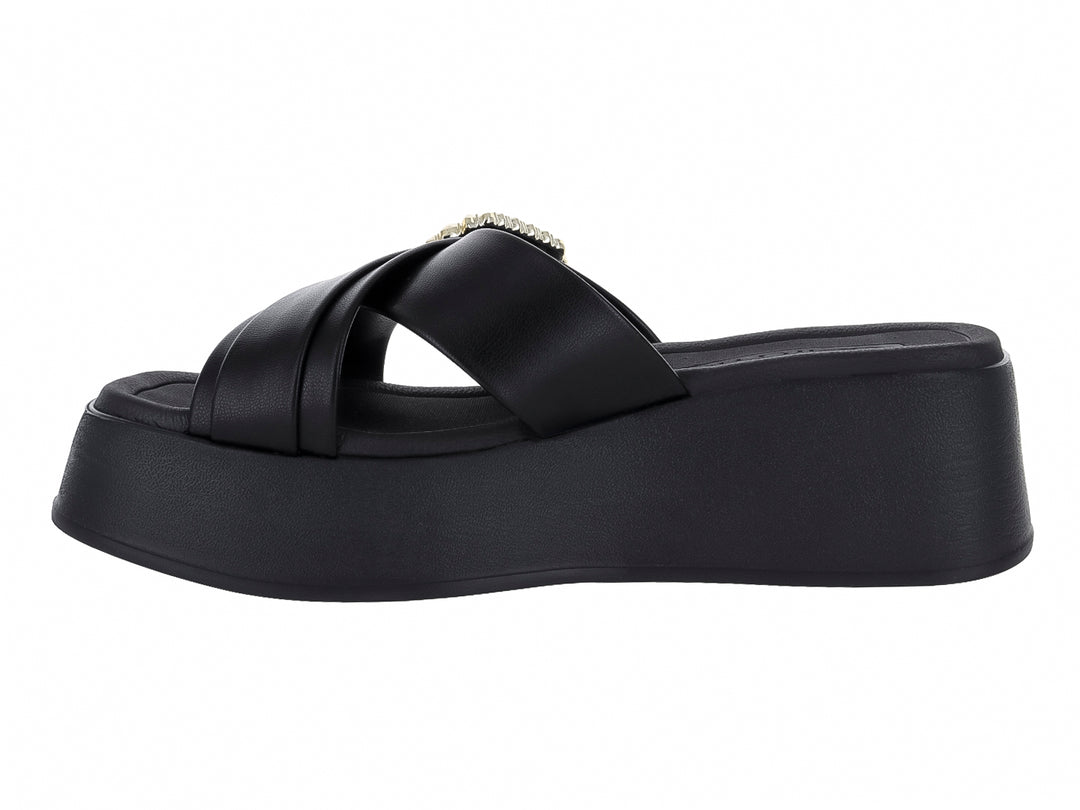 Sandalia negra de plataforma con hebilla decorativa dorada brillante en la parte superior.
