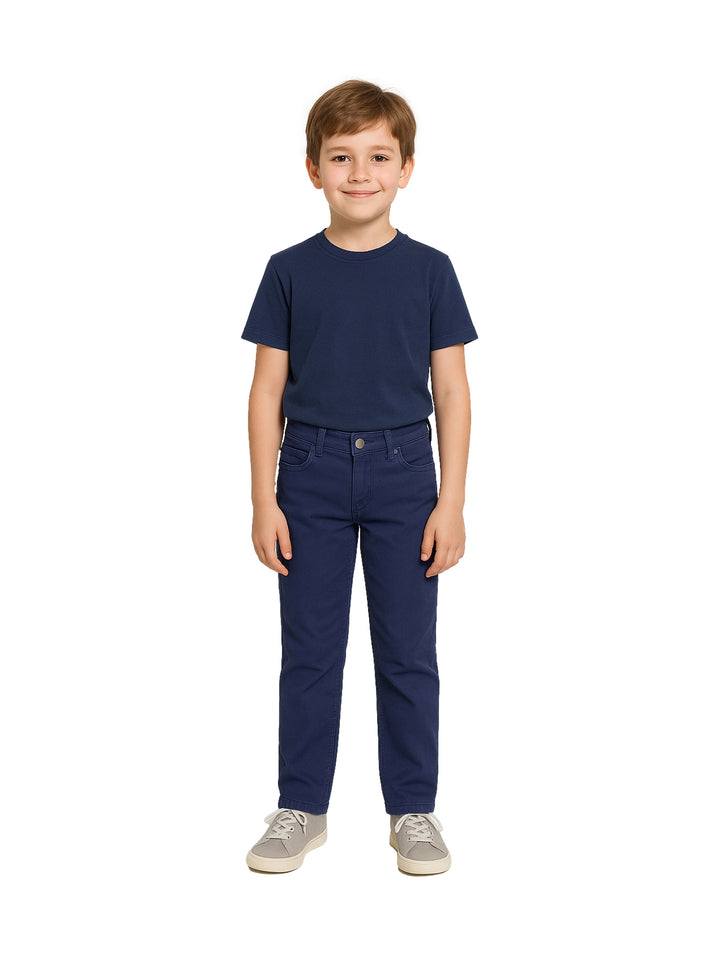 Niño vistiendo un pantalón casual color marino y camiseta a juego sobre fondo blanco.