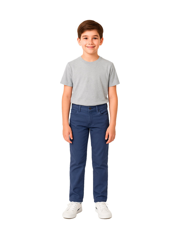 Niño vistiendo un pantalón color marino de corte recto y camiseta gris sobre fondo blanco.