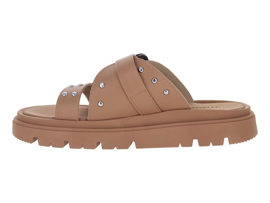 Sandalia slide color nude con suela de plataforma chunky, hebilla plateada y detalles de estoperoles.