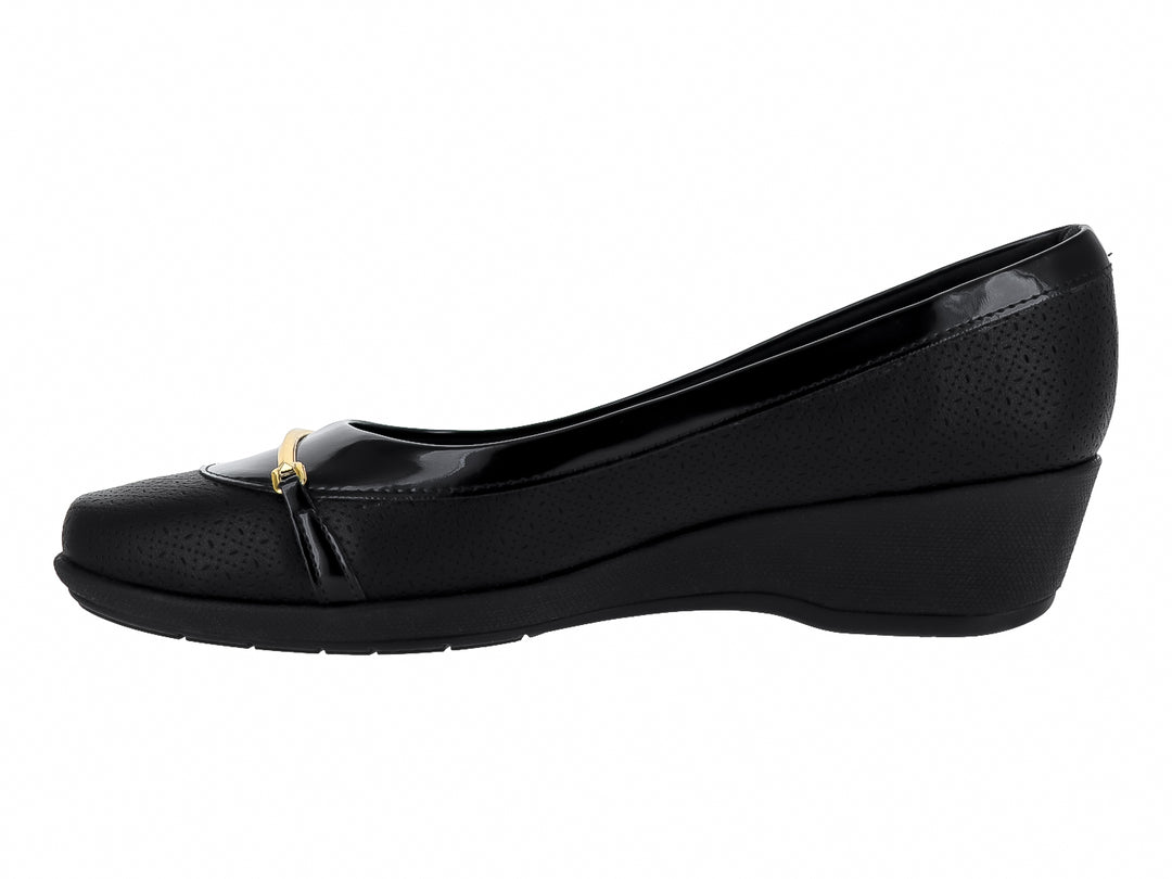 Zapato plano negro con cuña baja, detalle metálico dorado y textura perforada.