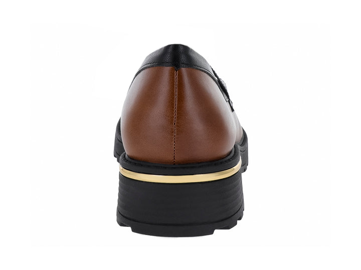Zapato mocasín color camel y blanco con suela gruesa negra y detalle dorado en el talón.