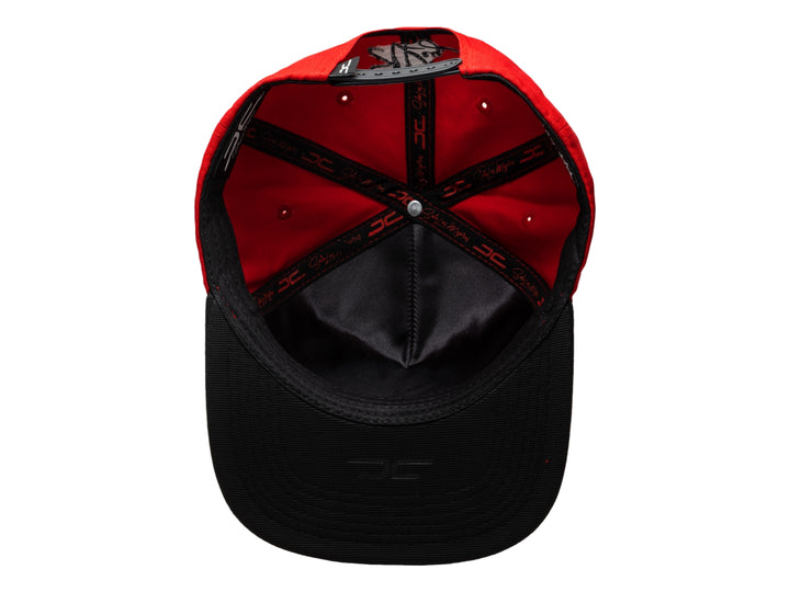 Gorra snapback roja con visera plana negra y bordado colorido de un león con corona en el frente.