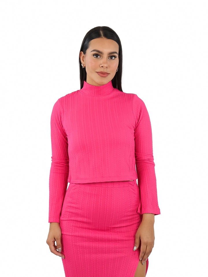 Suéter corto color fucsia con cuello alto y mangas campana en modelo.