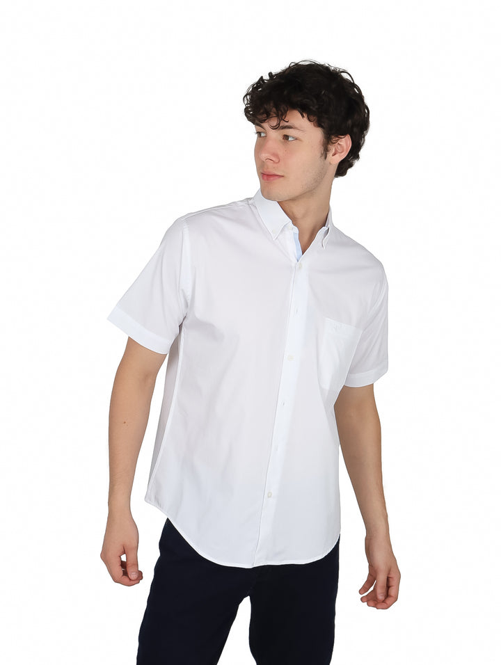 Hombre vistiendo una camisa blanca de manga corta con cuello y un bolsillo en el pecho.