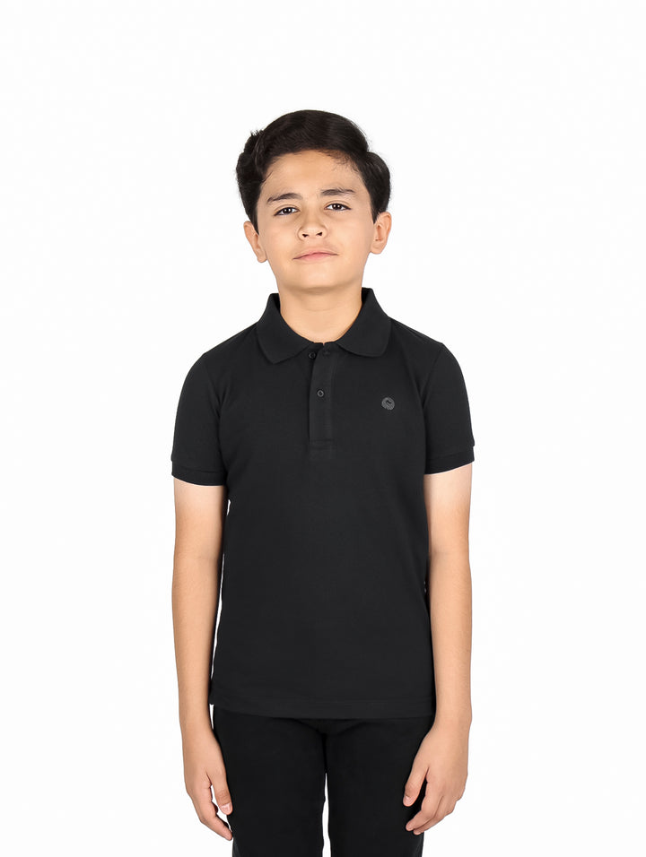 Niño vistiendo una playera polo color negro de manga corta.