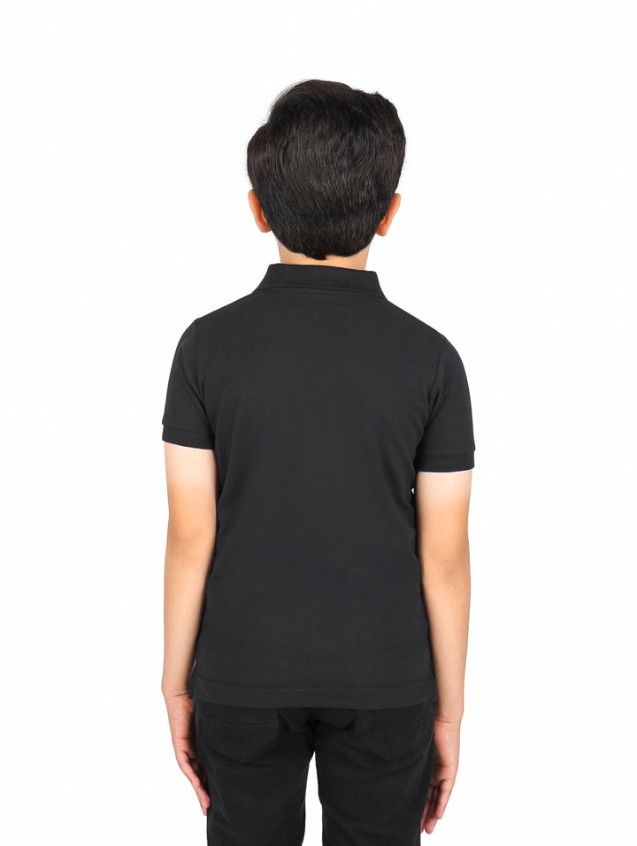 Niño vistiendo una playera polo color negro de manga corta.