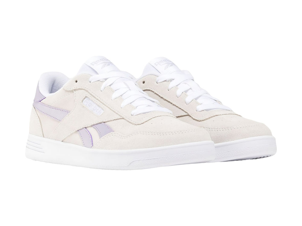 Tenis Reebok Court Advance color gris con detalles en lila y suela blanca.