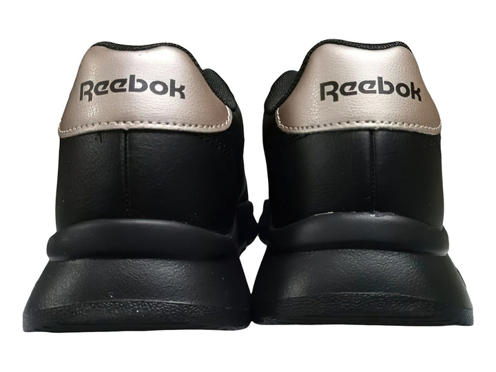 Tenis Reebok color negro con detalles en dorado y suela gruesa dentada.