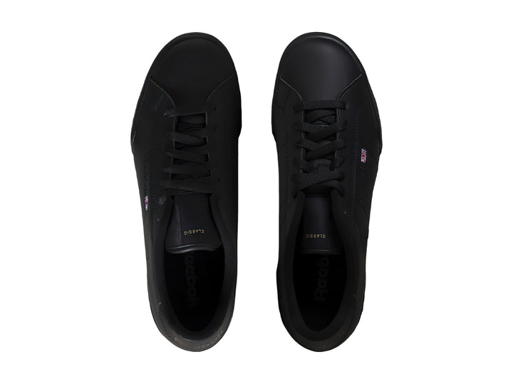 Tenis Reebok color negro, de corte bajo y material sintético con suela plana.