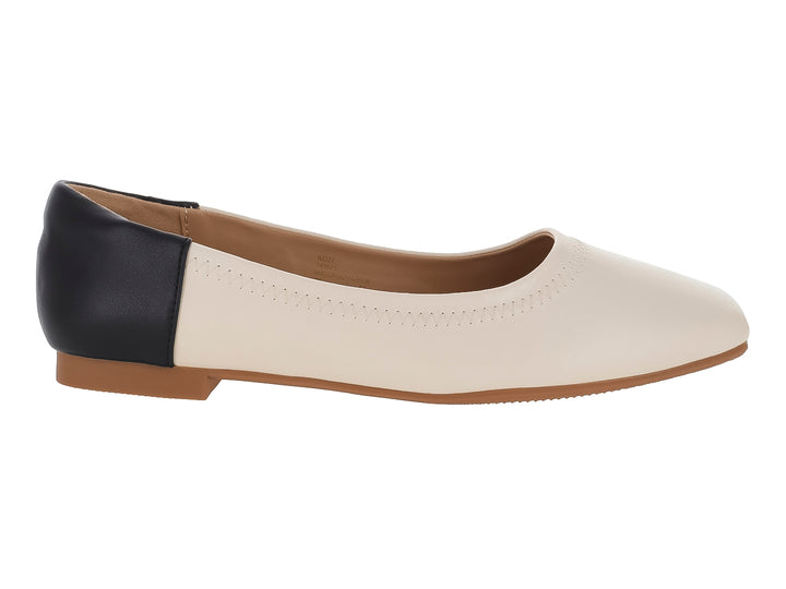 Zapato plano bicolor en color nude y negro con punta redondeada.