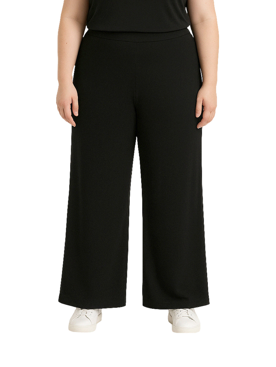 Mujer vistiendo pantalón recto ancho de color negro con pretina elástica y tenis blancos.