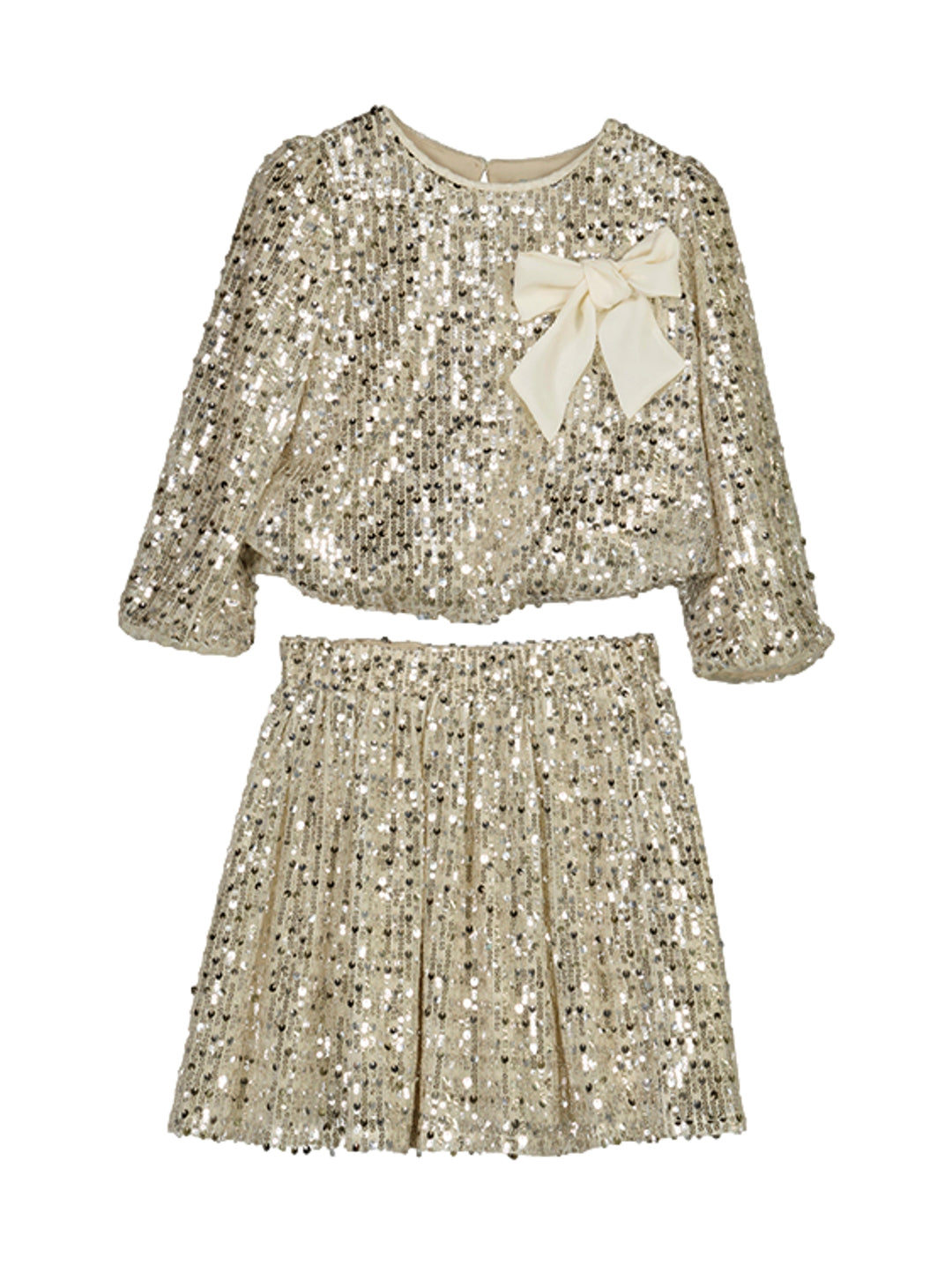 Conjunto de blusa y falda color champaña con lentejuelas y un moño decorativo blanco.