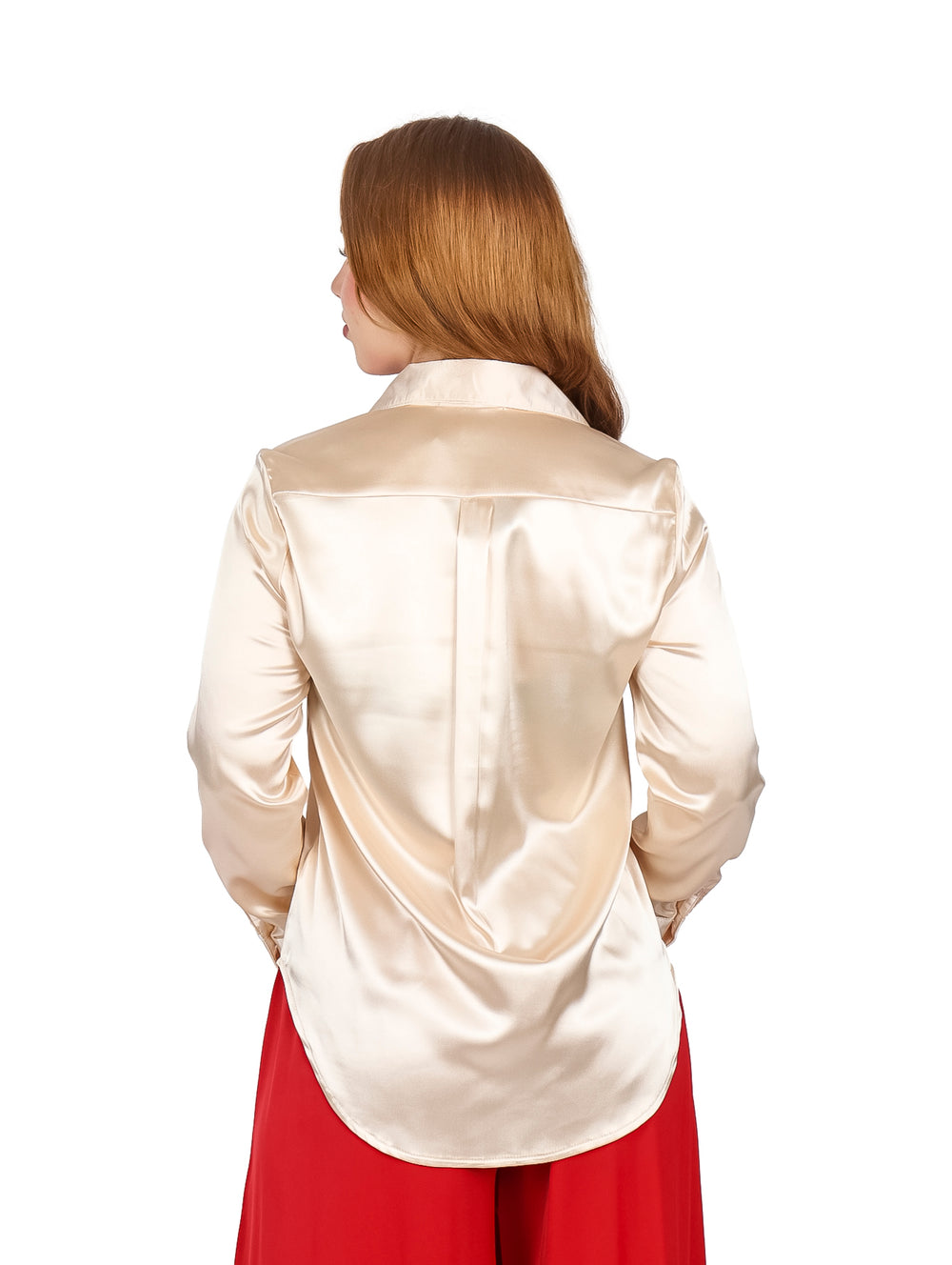 Mujer vistiendo una camisa de color champagne satinada con manga larga y bolsillos frontales.