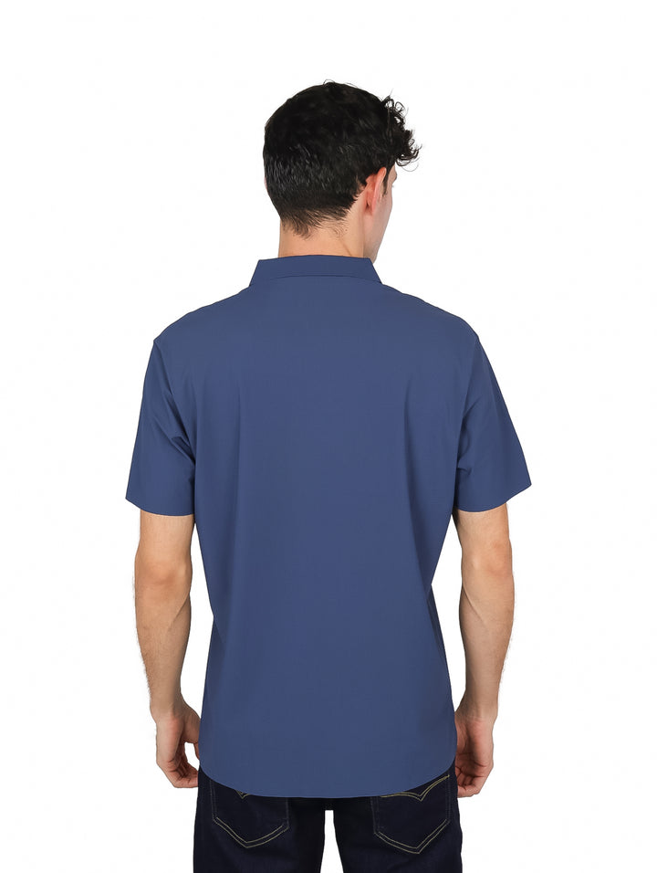 Hombre modelando una playera polo de color azul acero con cuello y botones.