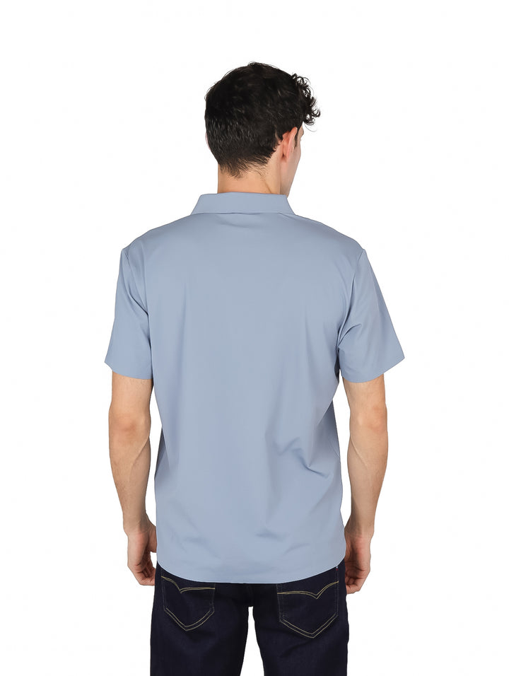 Hombre vistiendo una camiseta polo de color azul claro con cuello y manga corta.