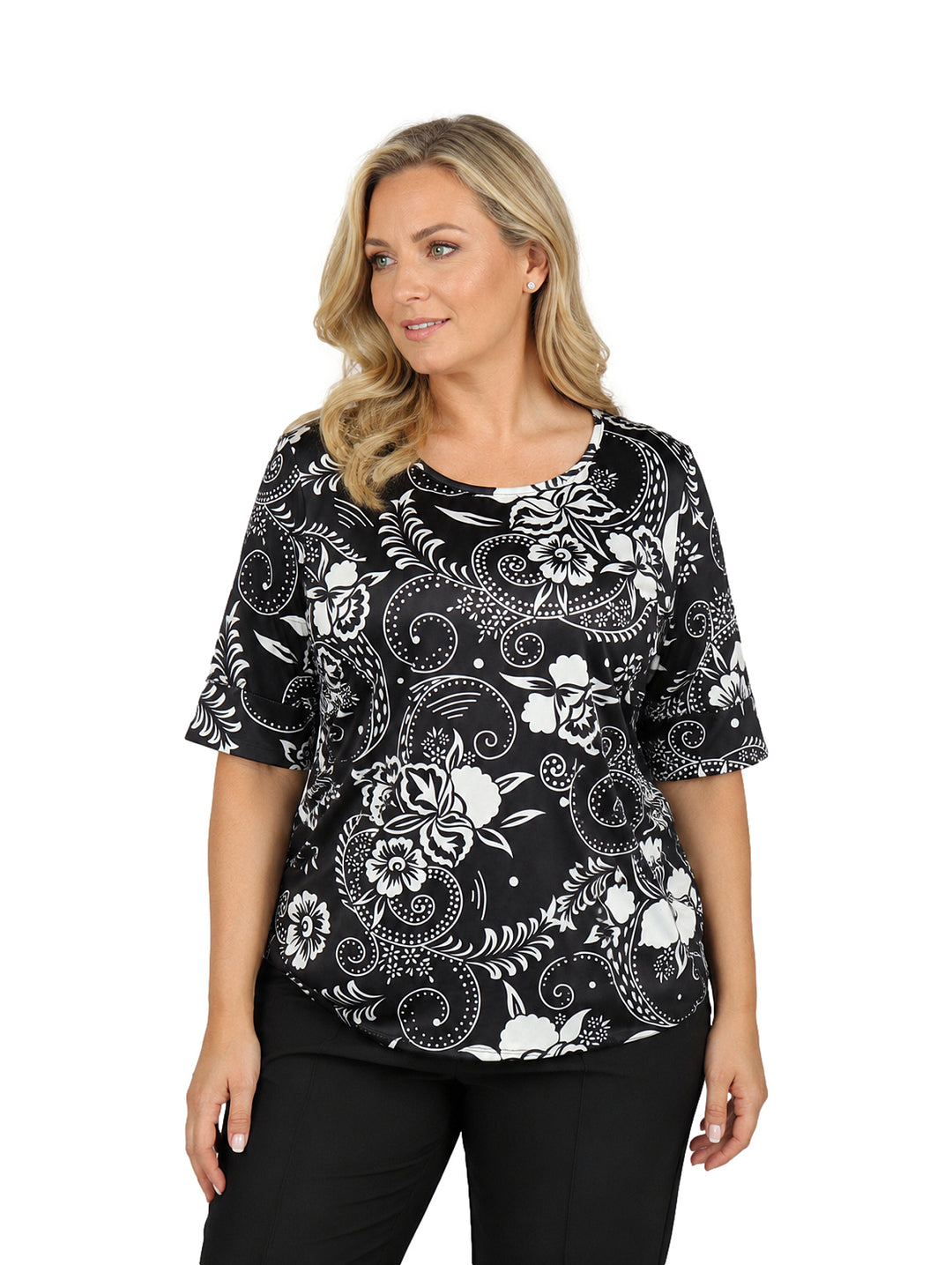 Mujer vistiendo blusa de manga corta color negro con estampado floral blanco y cuello redondo.
