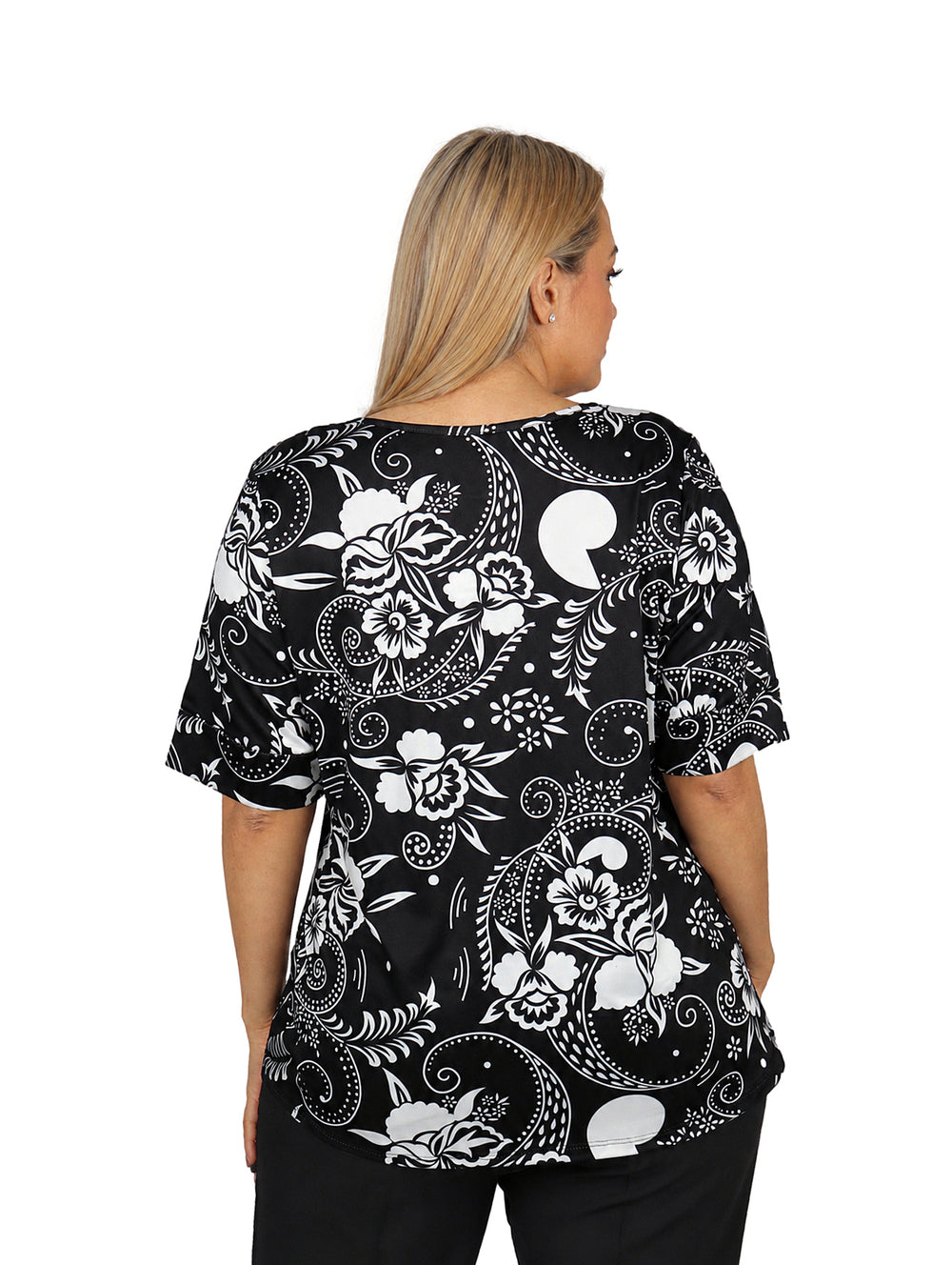 Mujer vistiendo blusa de manga corta color negro con estampado floral blanco y cuello redondo.