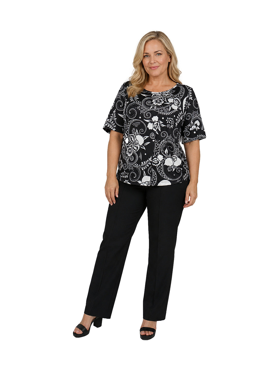 Mujer vistiendo blusa de manga corta color negro con estampado floral blanco y cuello redondo.