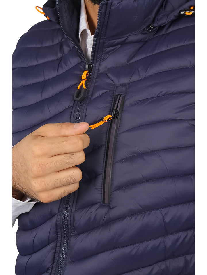 Hombre vistiendo un chaleco acolchado color navy con gorro y detalles en naranja.