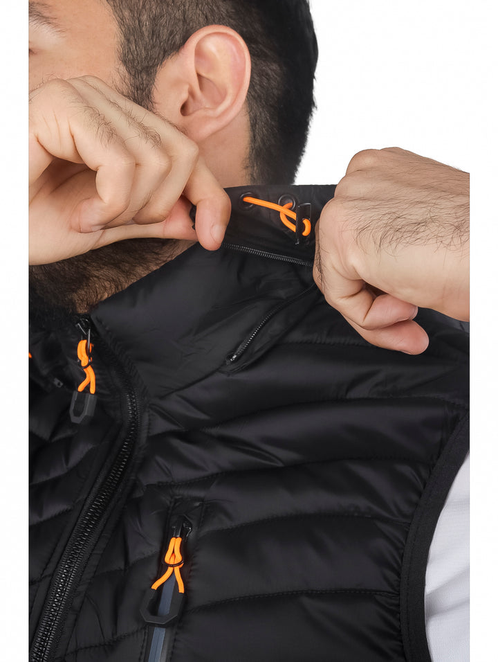 Hombre vistiendo un chaleco deportivo negro acolchado con gorro y detalles en naranja.