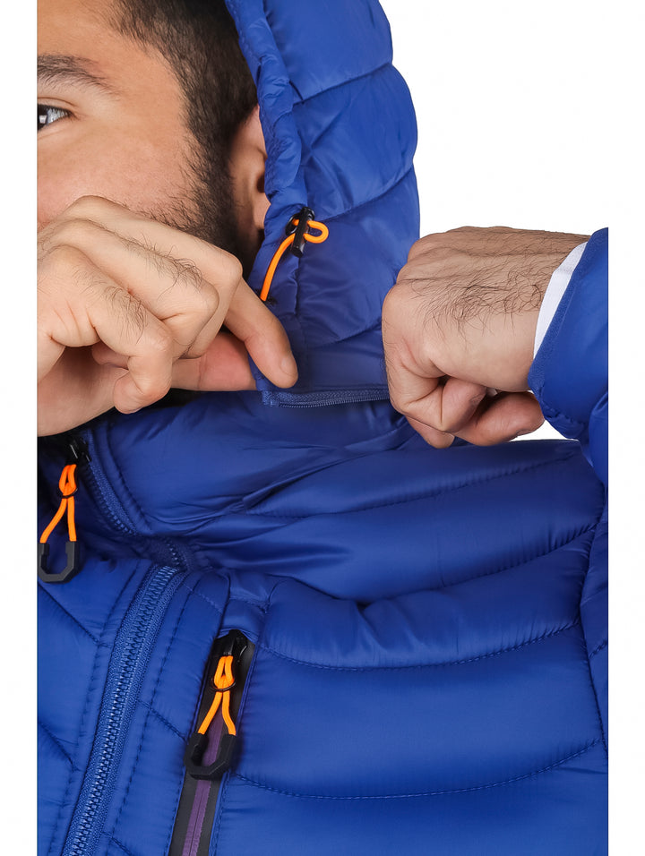 Hombre vistiendo chamarra acolchada color azul con gorro y detalles en naranja.